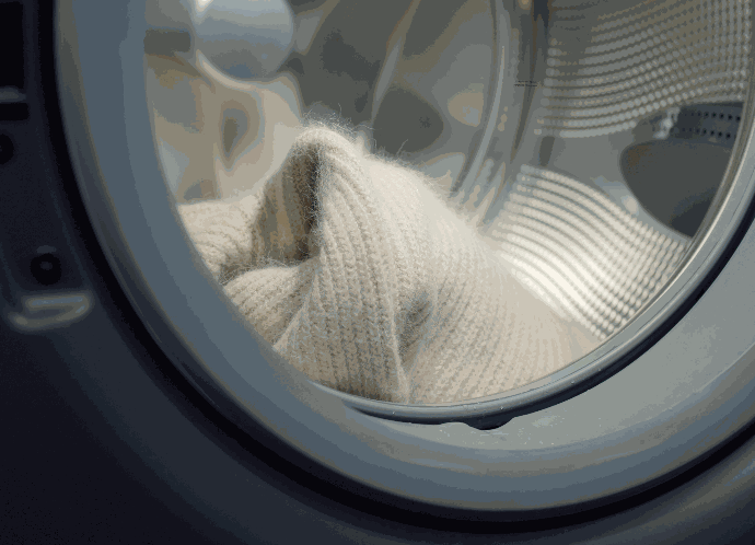 Kleidung aus Wolle sollte immer nur im Wollwaschgang gewaschen werden. Foto einer Waschmaschinen Trommel mit einem Wollprodukt
