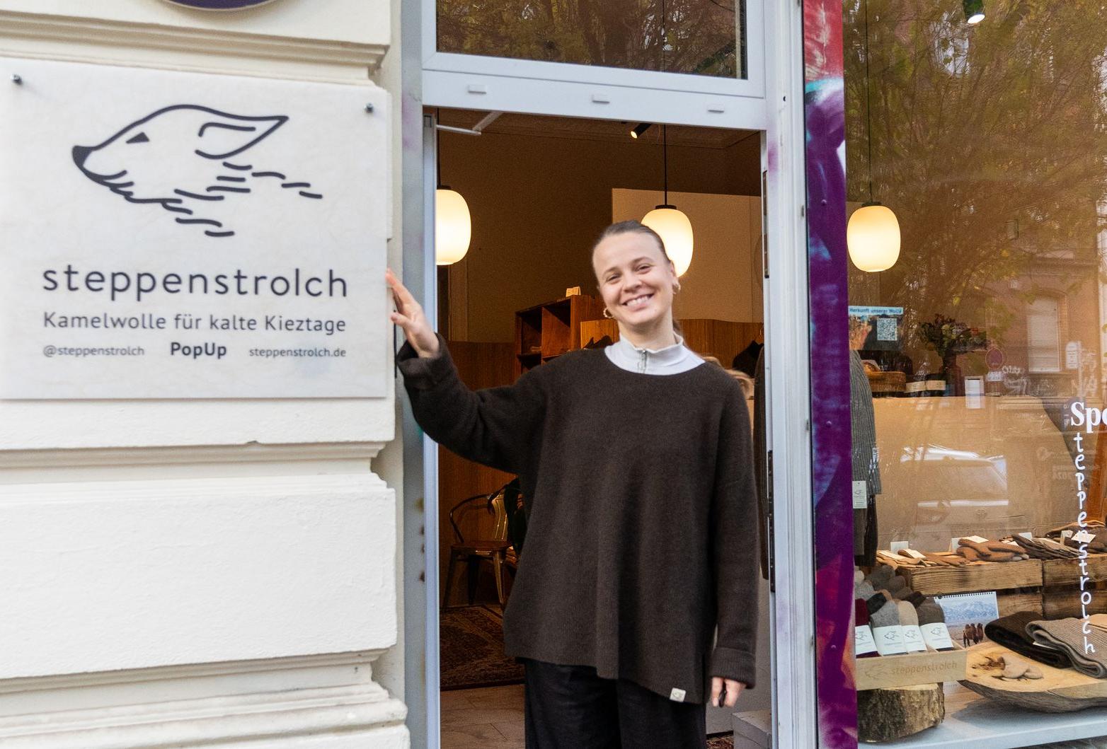 Eszter manages our shop in Berlin until February A woman in front of a shop with the steppenstrolch logo