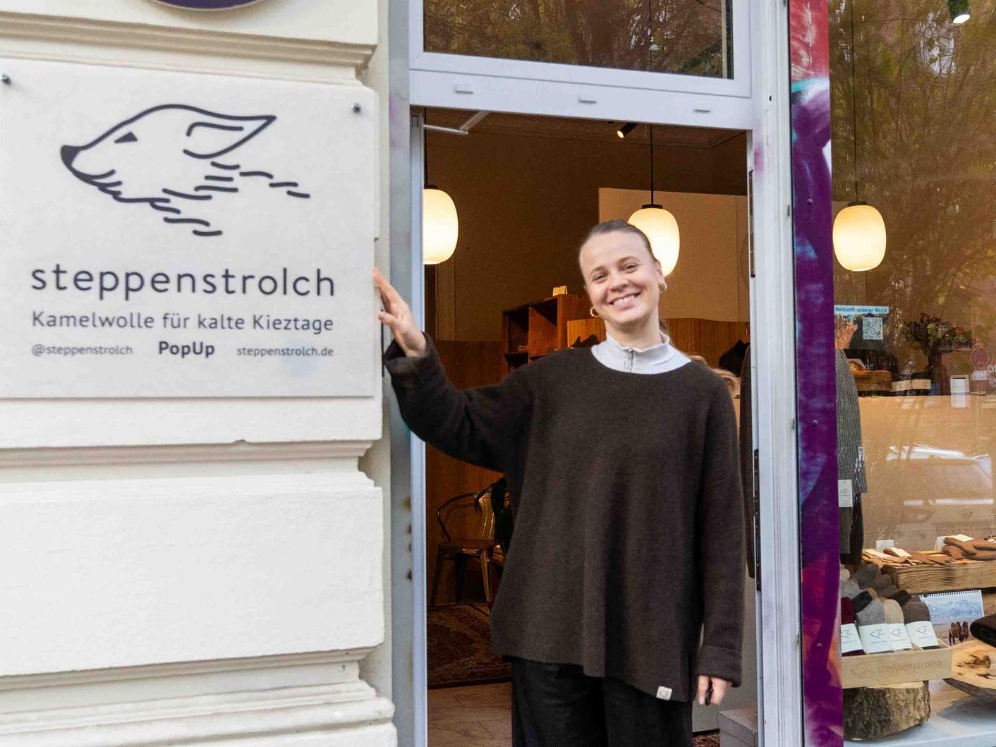 Unser steppenstrolch Laden in Berlin Eine lachende Frau steht vor dem steppenstrolch Pop-Up in Berlin