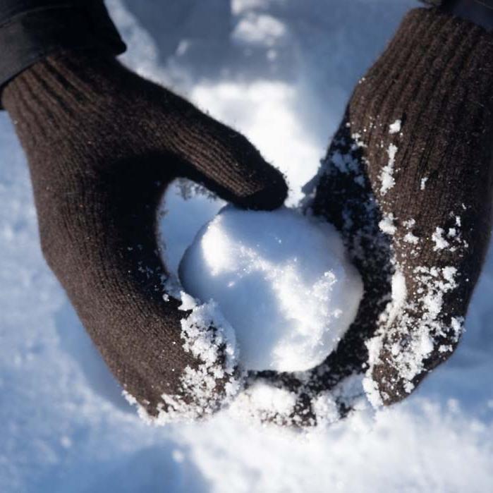 Fäustlinge und Handschuhe aus Yak und Kamelwolle Dunkelbraune Fäustlinge halten Schneeball