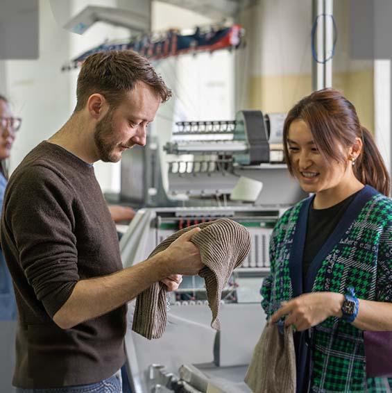 Malte und Otgoo in der Produktion Ein Mann und eine Frau begutachten Wollprodukte