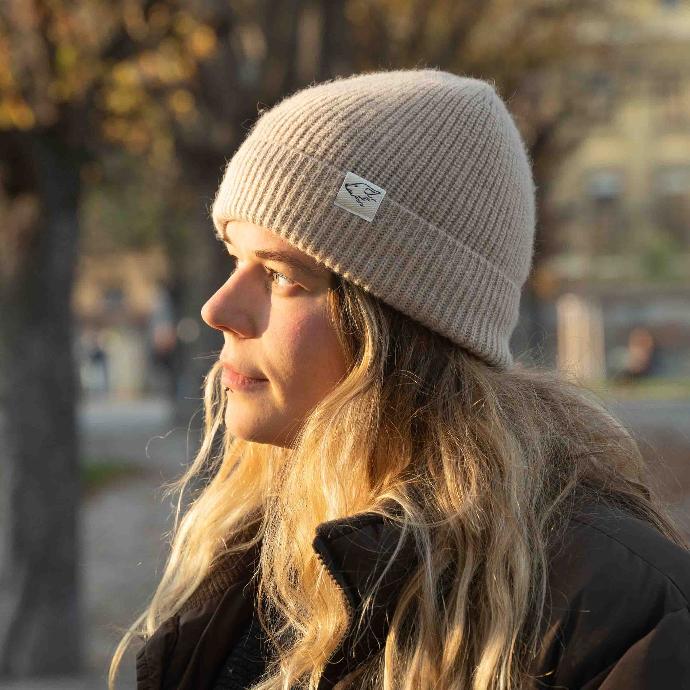 Beanie aus Kamelwolle, beige Frau mit Wollmütze aus Kamelwolle