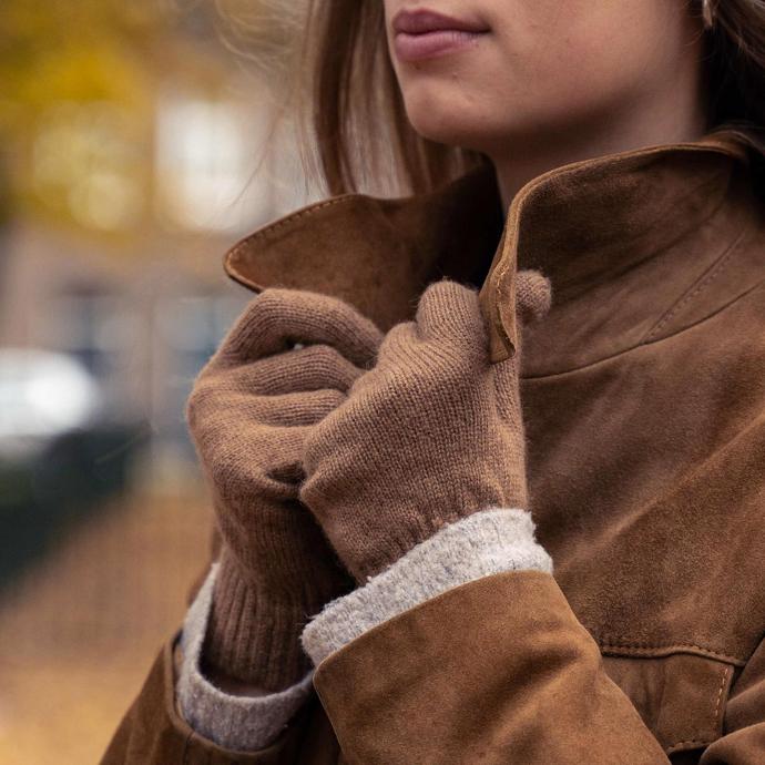 Unsere klassischen Handschuhe aus Kamelwolle Braune Handschuhe aus Wolle halten Kragen einer braunen Jacke